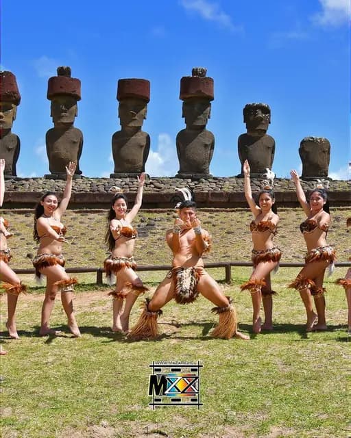 Bailarines de Kahuira con vestuario Rapa Nui frente a los moai en Isla de Pascua